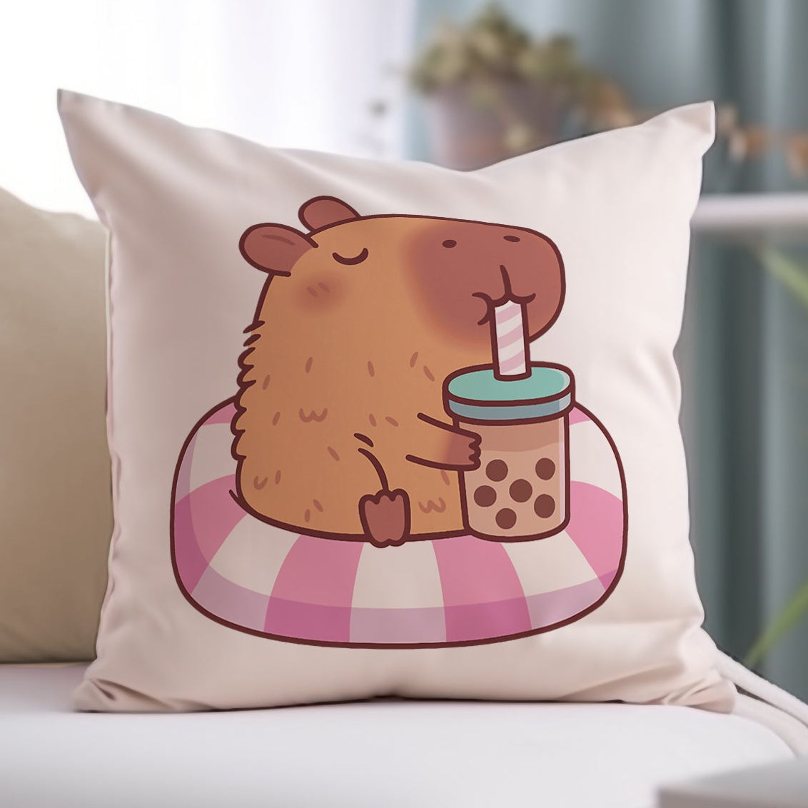 Decorative pillow with a cartoon capybara holding a bubbletea cup on a white couch.