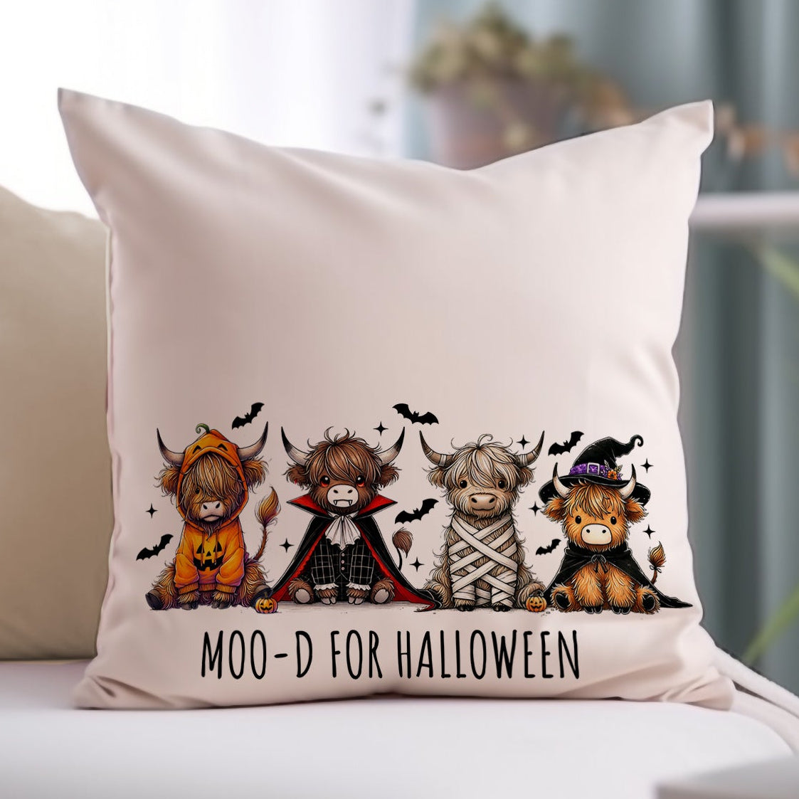 Decorative pillow with Halloween-themed cow illustrations on a couch.