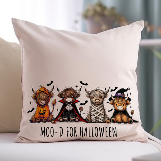 Decorative pillow with Halloween-themed cow illustrations on a couch.