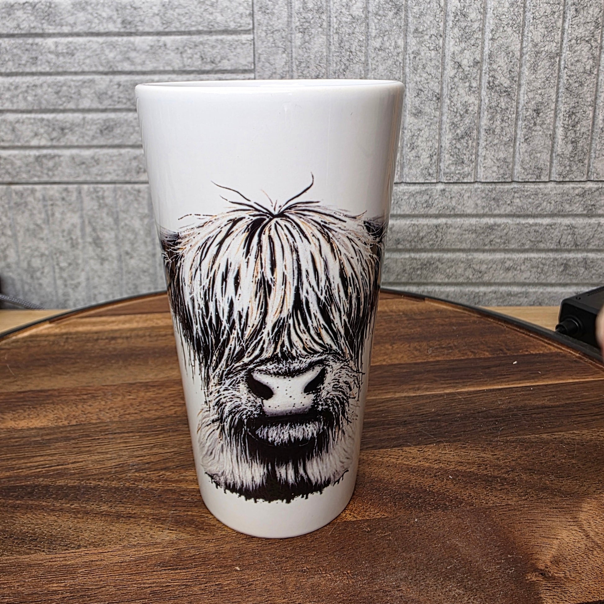 Latte Mug with a black and white Highland Cow design on a wooden table